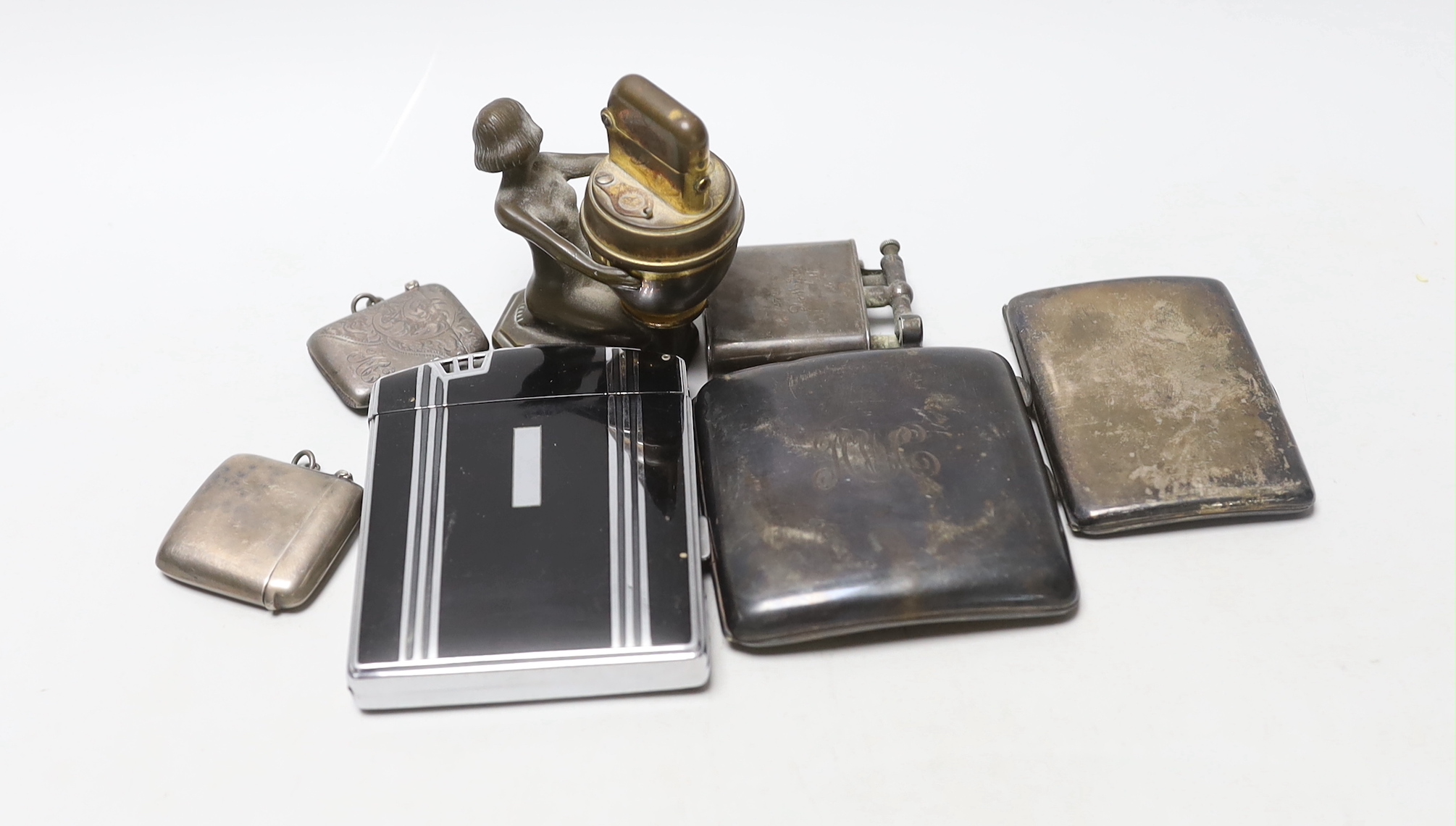 Two silver cigarette cases, two silver vesta cases and three other smoking related items.
